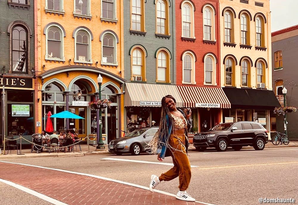 Woman walking in front of colorful depot town buildings