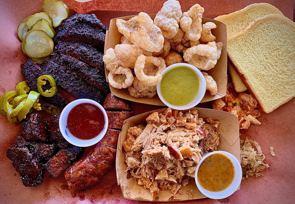 Arrangement of smoked meats and sides on a piece of butcher paper.