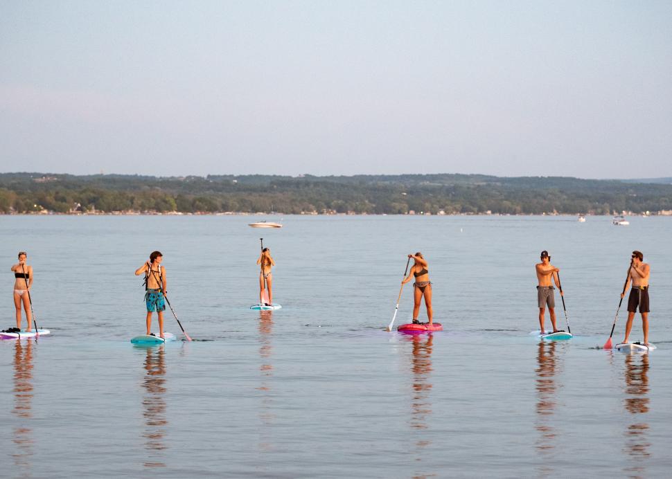 Group of people stand up paddleboarding