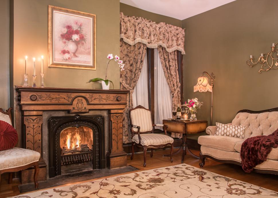 Interior of the Penfield Suites parlor room with the fireplace running