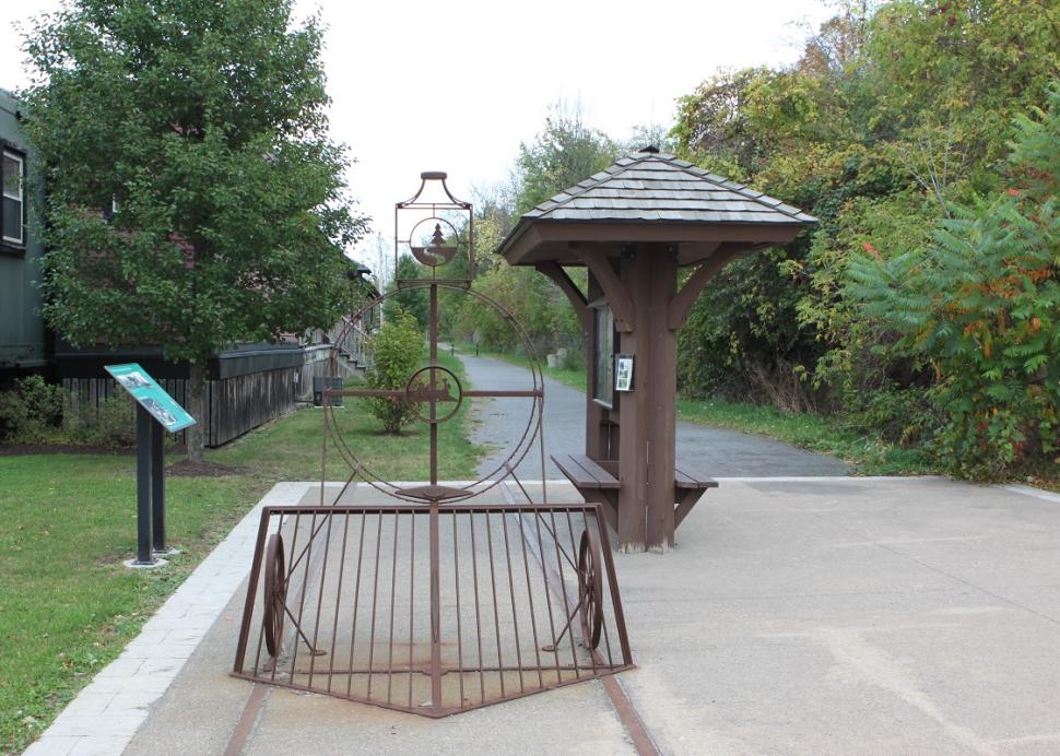 A model train made from wire sits out front of the entrance to the Victor Hiking Trails