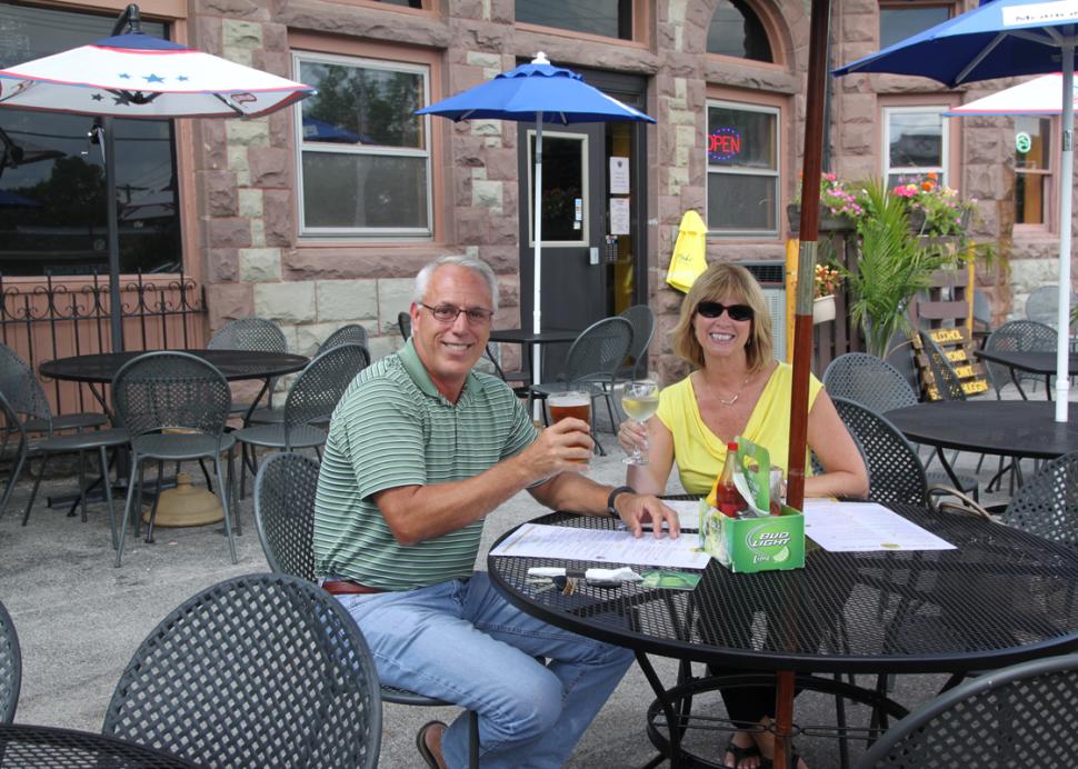 bee-hive-brew-pub-canandaigua-couple-outside-toasting-glasses