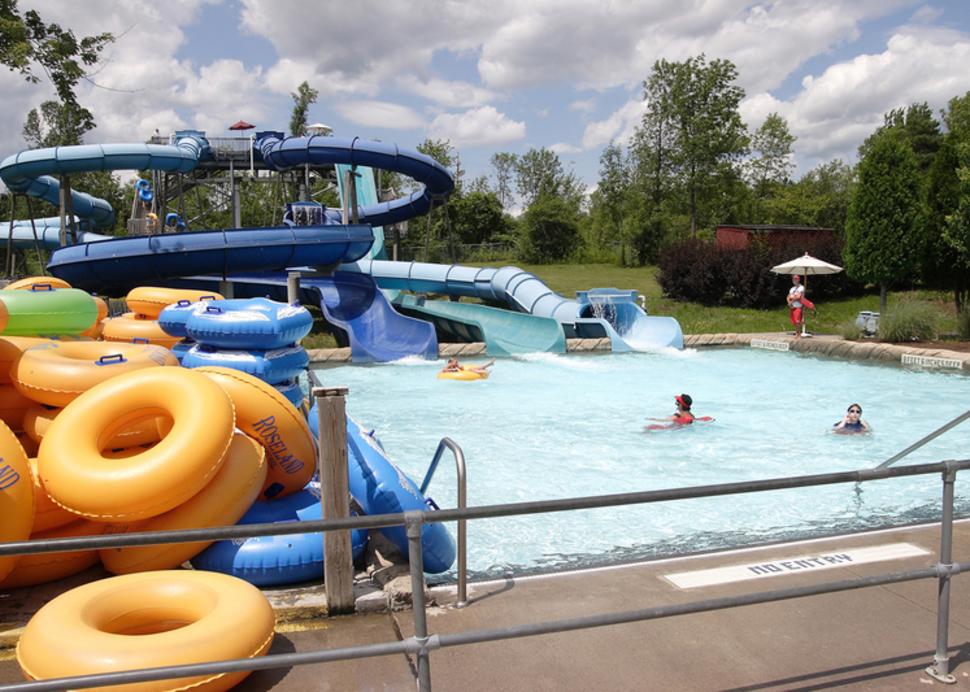 A water slide ends with a splash as it exits into a pool