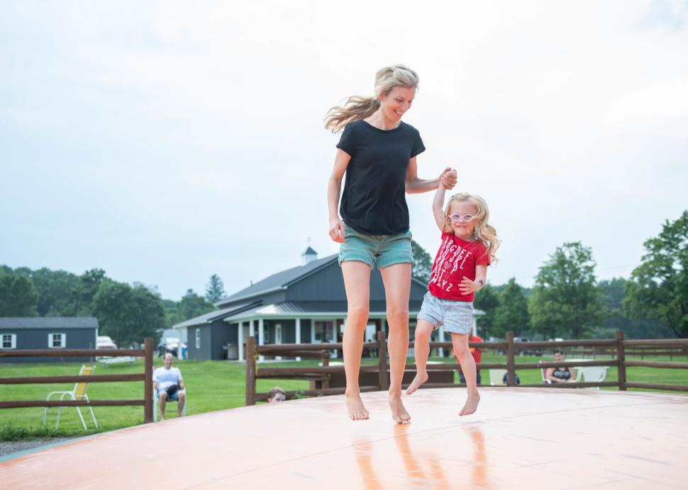 A kid and her mother play on the trampoline at the Pick n' Patch in Stanley