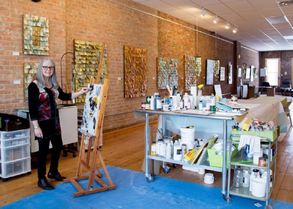 Jeanne Beck poses for a photo while painting in her studio in Canandaigua