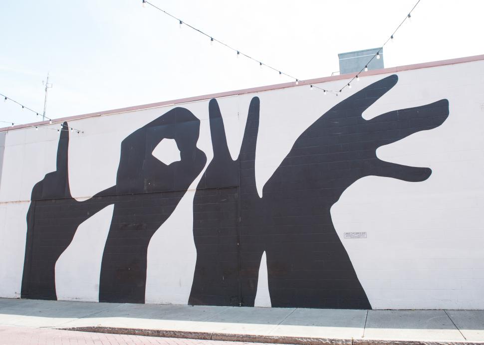 A mural of silhouetted hands painted on a building on Linden Street