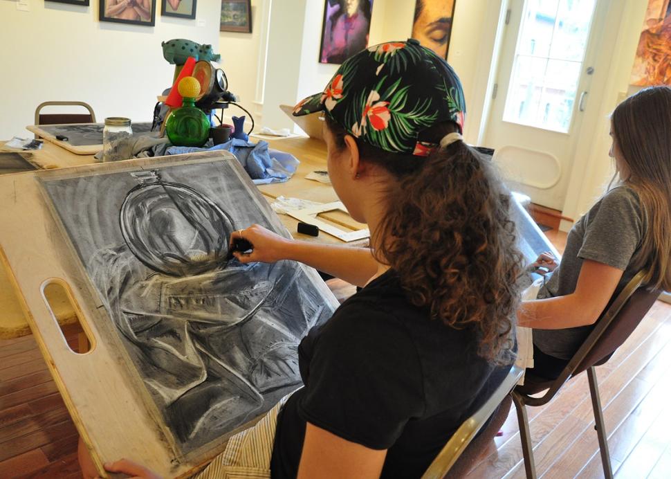 A artist paints a picture at Main Streets Arts in Clifton Springs