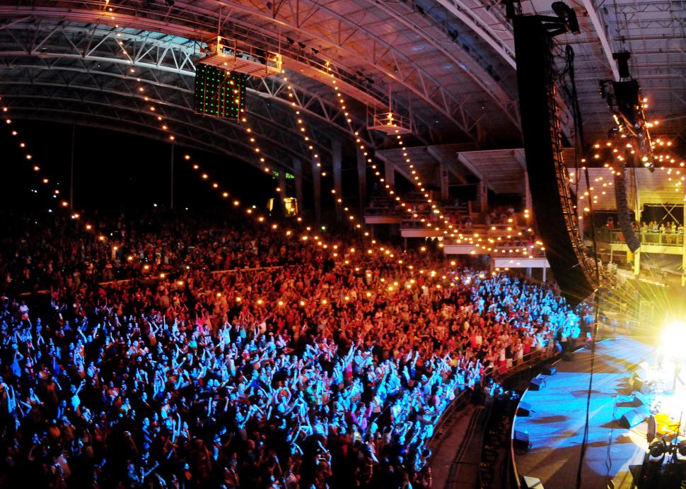 Photo of a crowd lit up red white and blue during a concert at the CMAC Center in Canandaigua