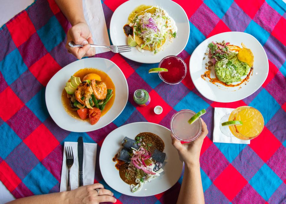 Overhead photo of a table with four plates full of food at Rio Tomatlan