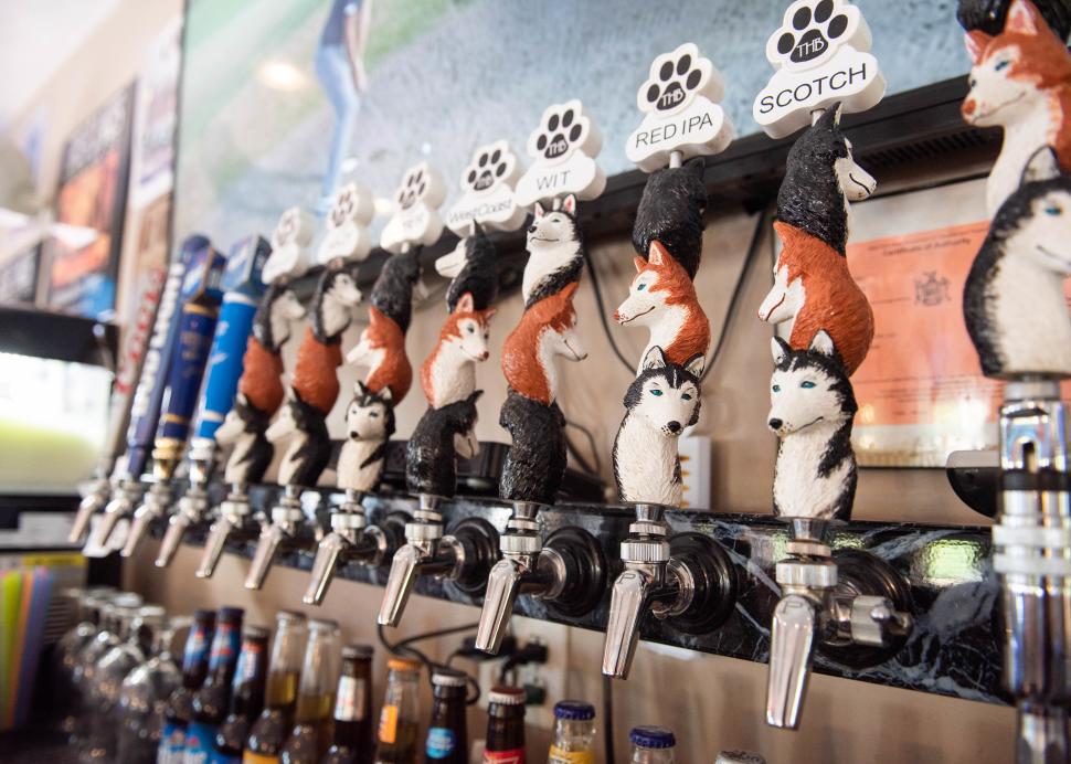 Closeup of taps holding craft brews from Three Huskies Brewing
