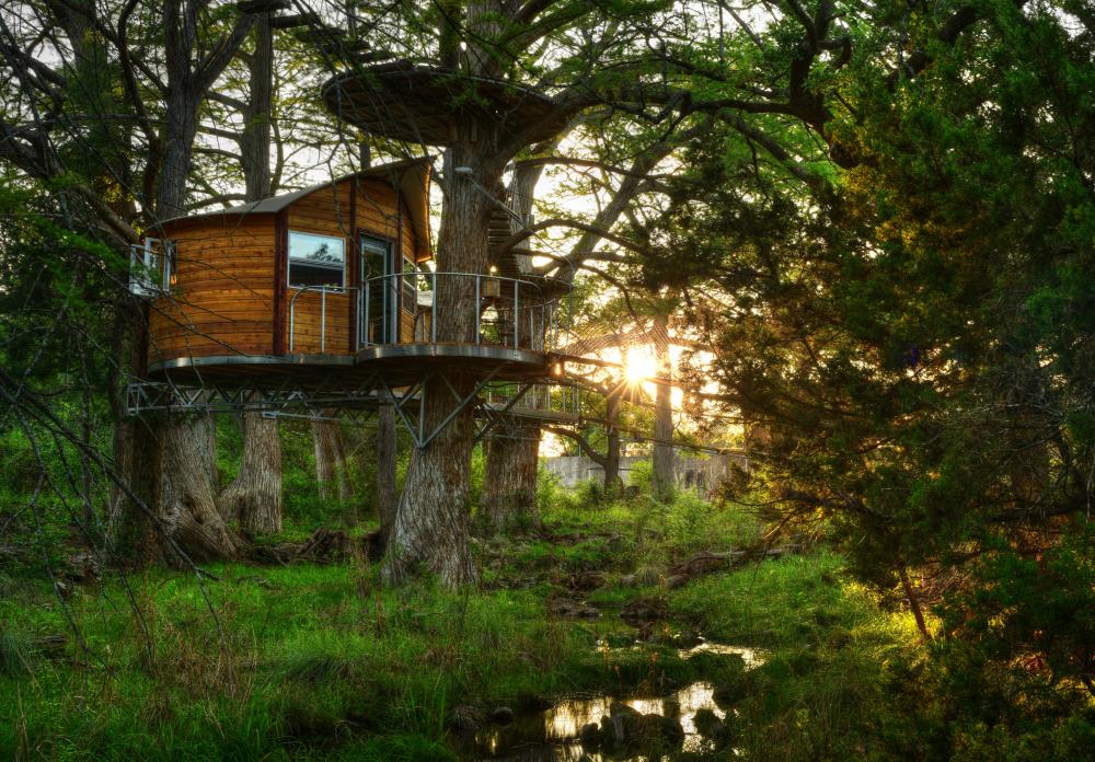 Photo of a treehouse retreat among the trees and overlooking a small creek at Cypress Valley
