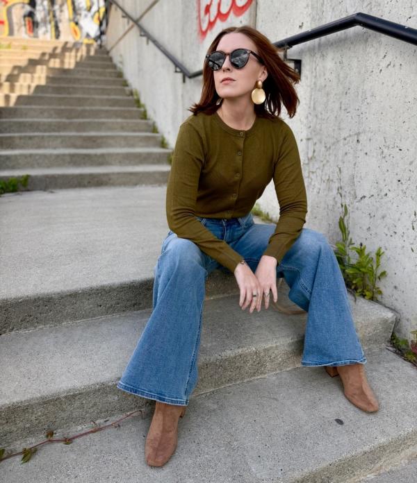 Woman sits on concrete steps looking past the camera