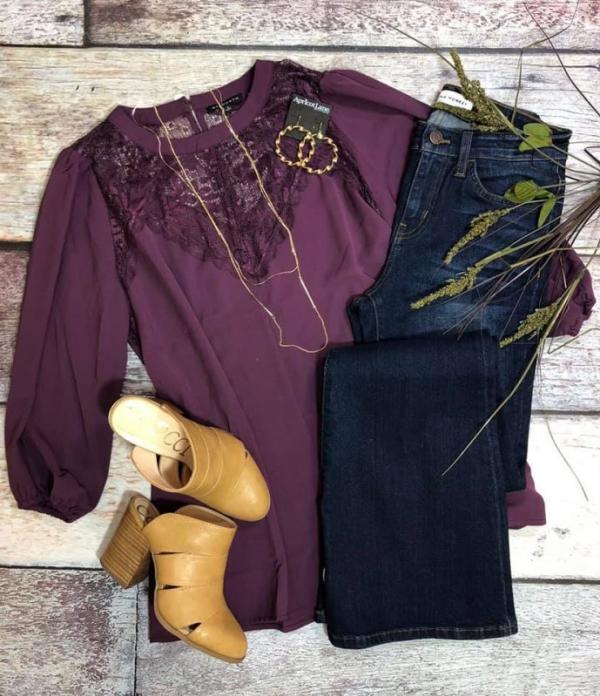 A purple blouse, folded pair of jeans, high heel shoes and accessories from Apricot Lane