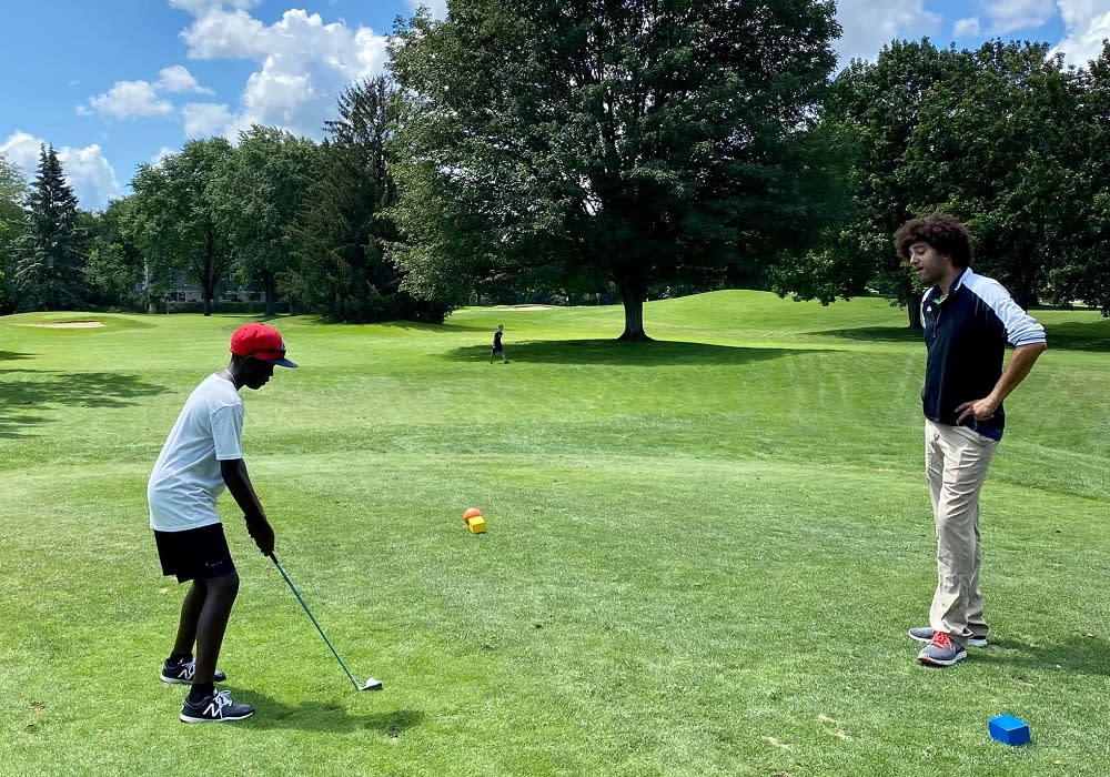 trainer instructs young golfer at Georgetown country club