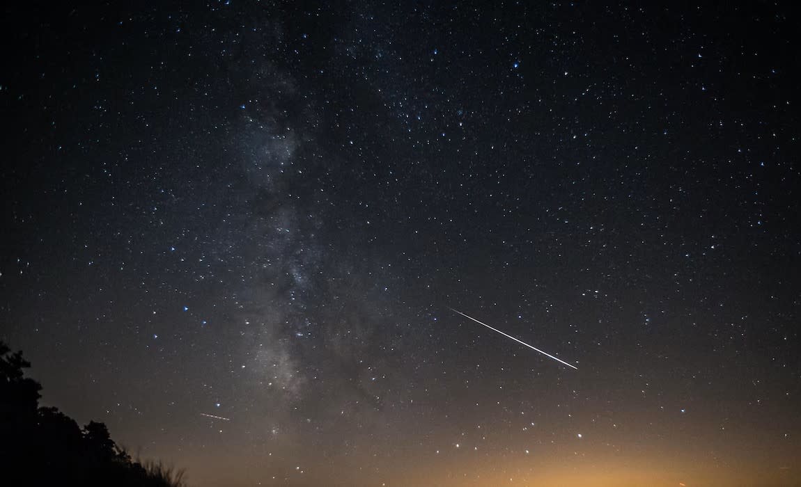 A shooting star streaks through the night sky above Mackinac Island during a meteor shower