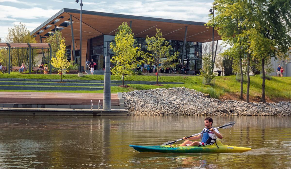 Man kayaking solo on St. Marys River in Fort Wayne, Indiana in front of Promenade Park