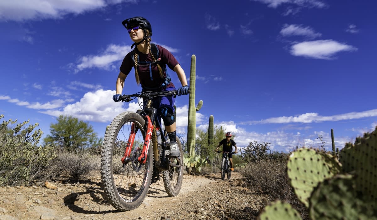 A couple mountain biking through the Sonoran Desert