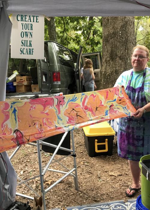 Artist displays a colorful handmade silk scarf at a booth during the Monte Sano Arts Festival in Huntsville.