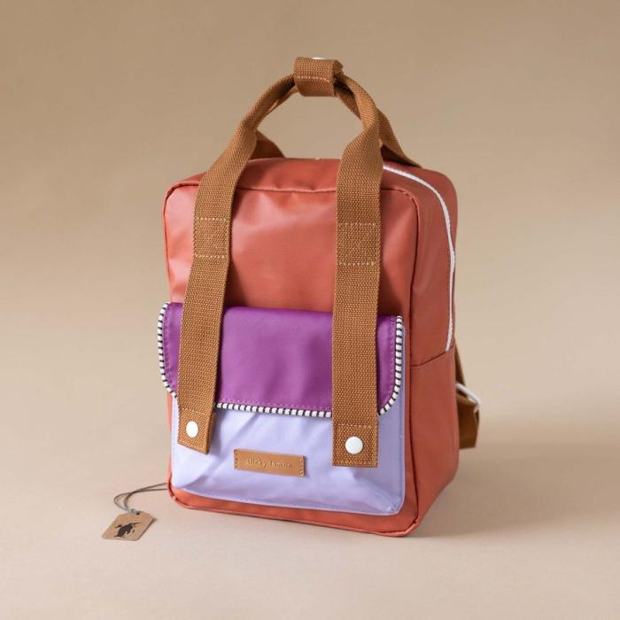 A backpack with brown straps and brown and purple pockets