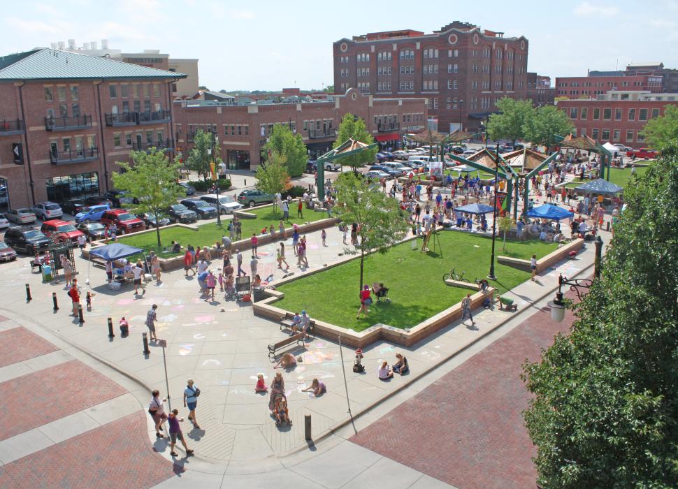 Aerial view of a crowd gathered in a pedestrian park with green spaces in Downtown Wichita, KS