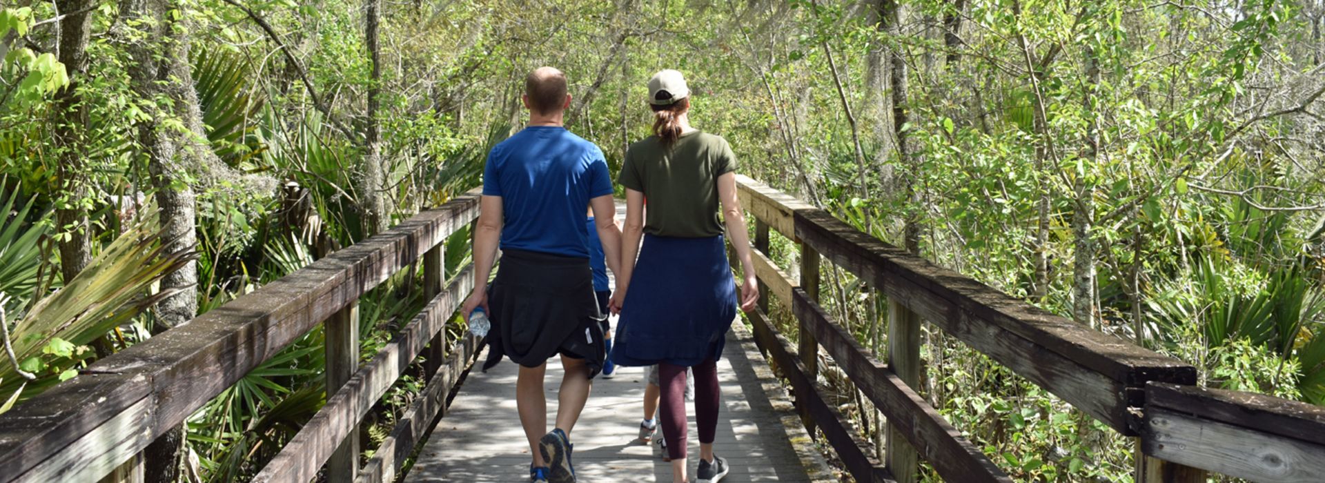 Couple walking on the boardwalk through Barataria in Jefferson Parish