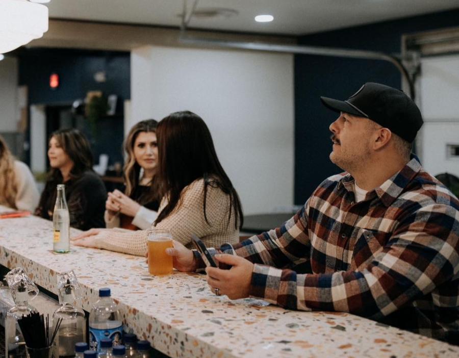 People drink beer at the counter at Sunday Service Motor Company