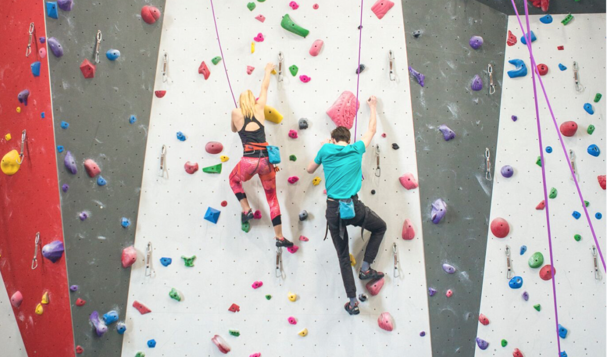 A couple climb a wall together at Bliss Climbing and Fitness in Wichita