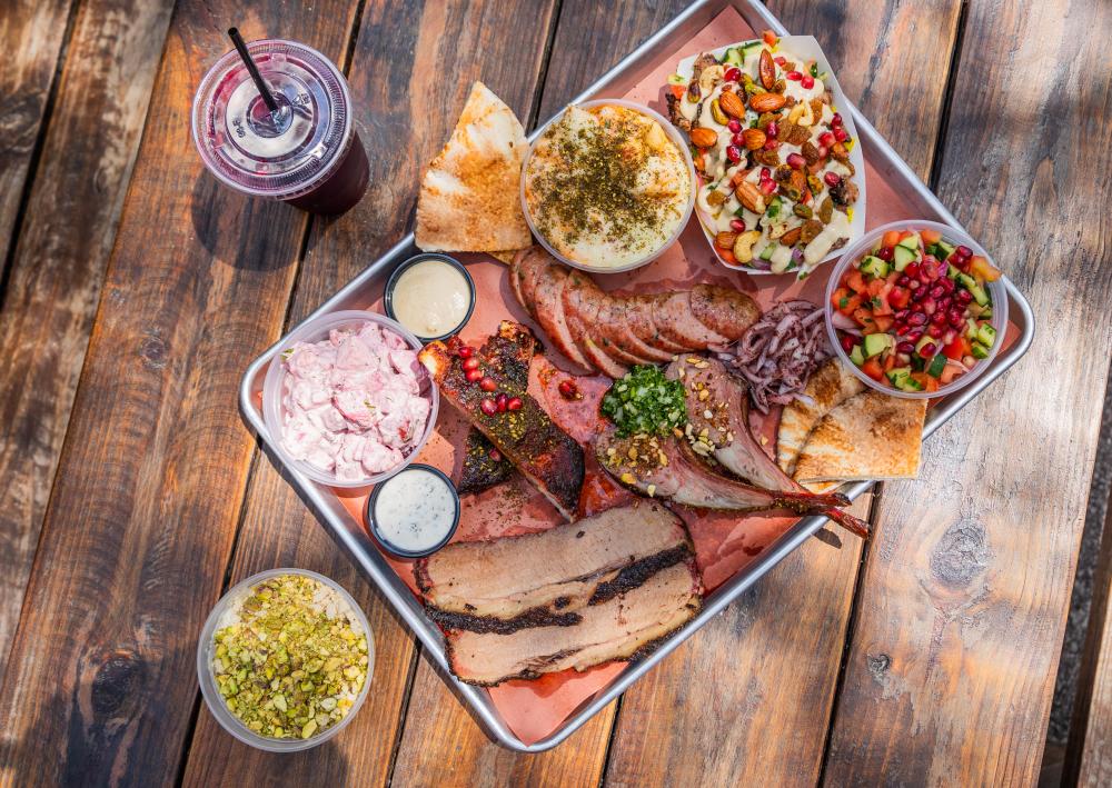 Photo of a tray of barbecue from KG BBQ sitting on a wooden table.