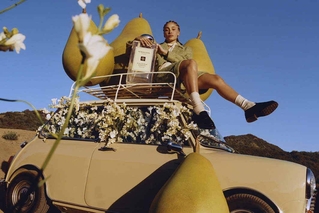 Jo Malone Perfume: Woman riding on a car with pears