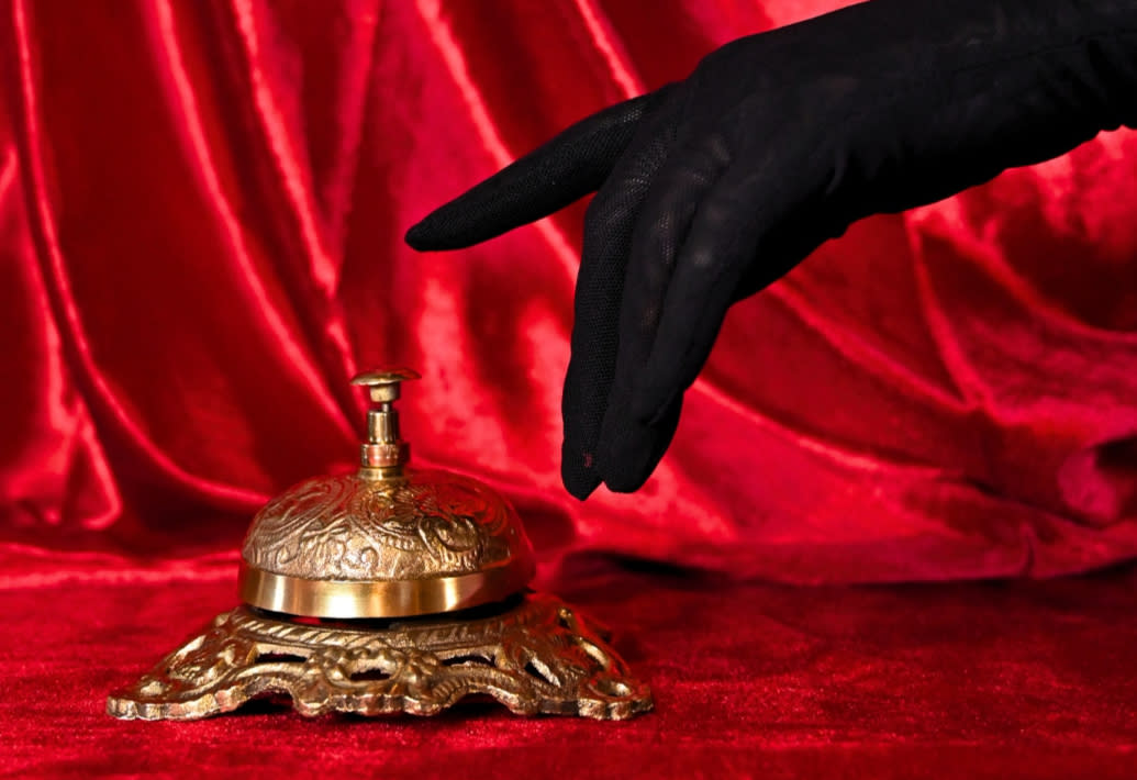 Gloved finger ringing a bell for the Hotel Immortale event at the Kimpton Cottonwood Hotel.
