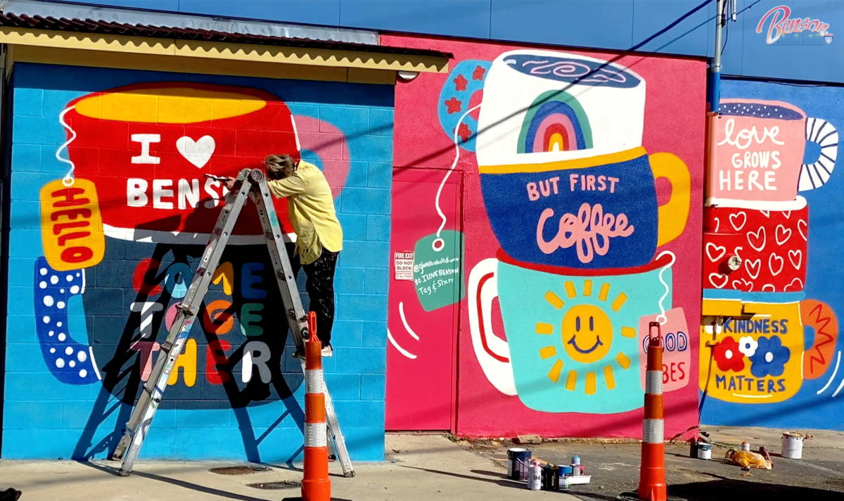 A vibrant and colorful mural in Benson, NC with giant coffee mugs that include sayings such as "Kindness Matters" and "I Love Benson".
