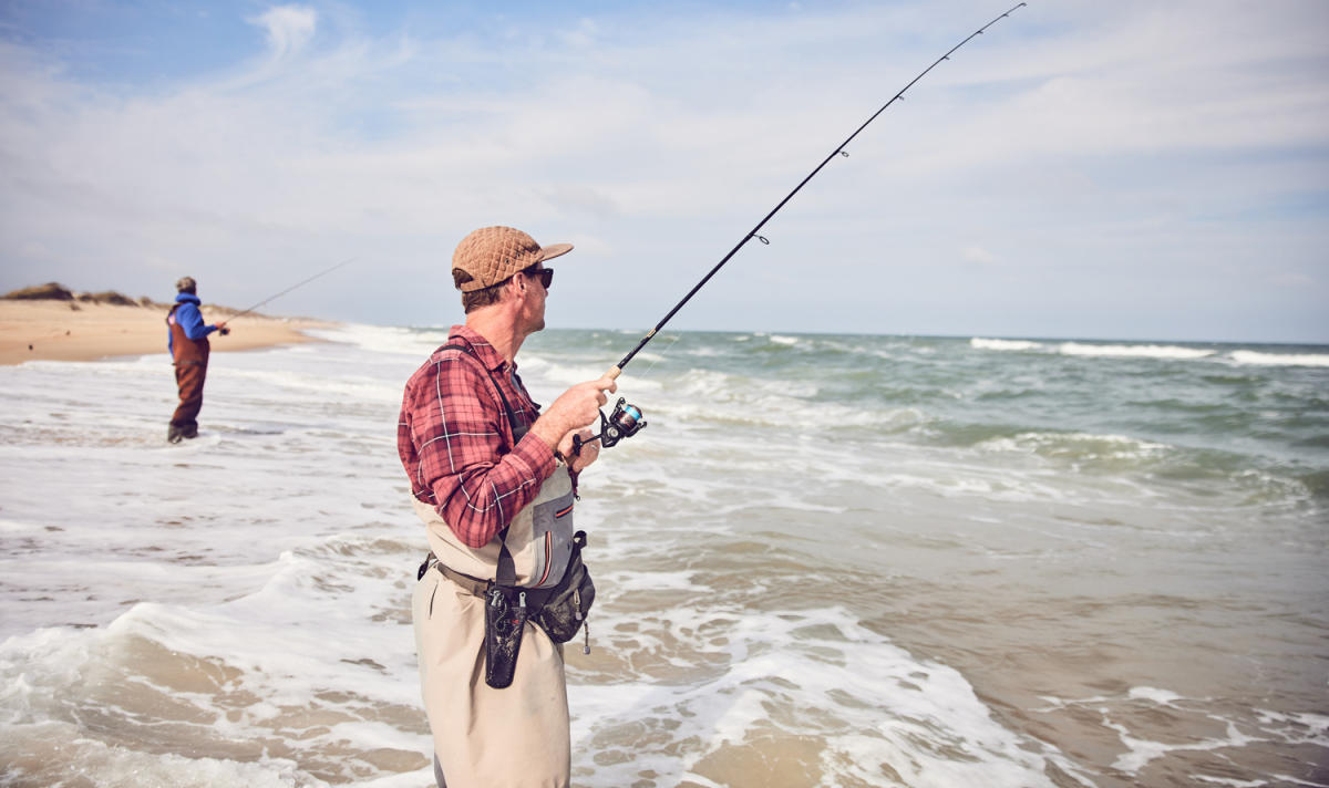 A beachgoer surf fishing along the shoreline on Hatteras Island, NC.