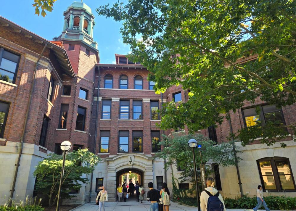 Campus brick and concrete building with windows and with archway and tunnel passing through the building