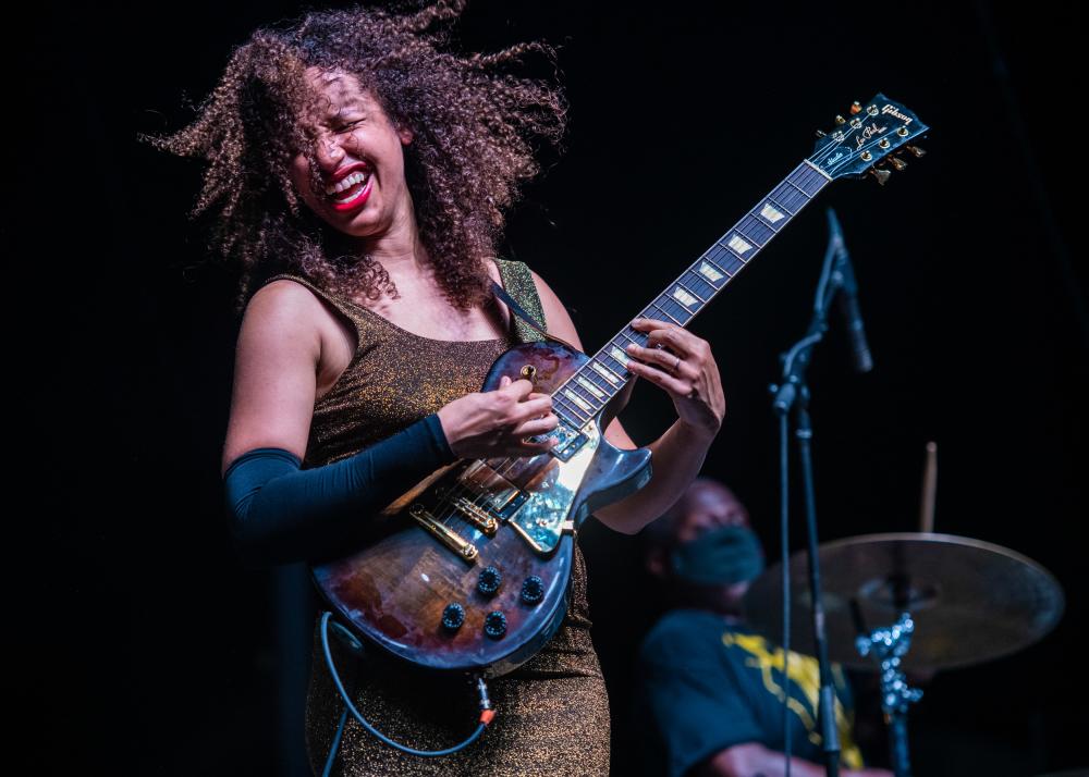 Femal guitarist Jackie Venson plays the guitar on stage at Love and Lightstream event in Austin Texas