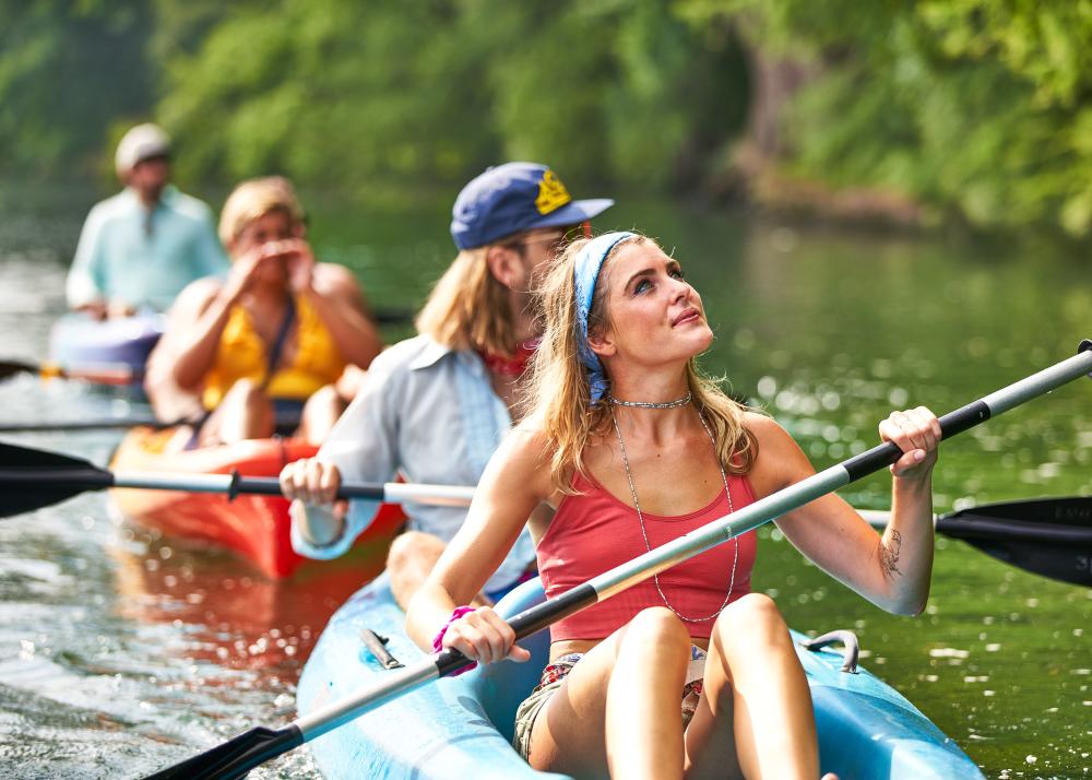 Photo of a woman and three others behind her in rental kayaks from Rowing Dock