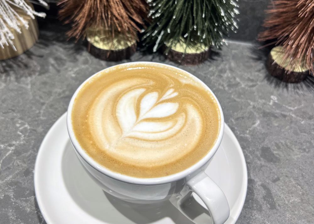 white coffee mug filled with a latte and topped with foam latte art