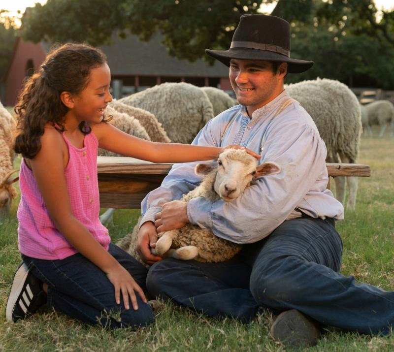girl petting a sheep at nash farm