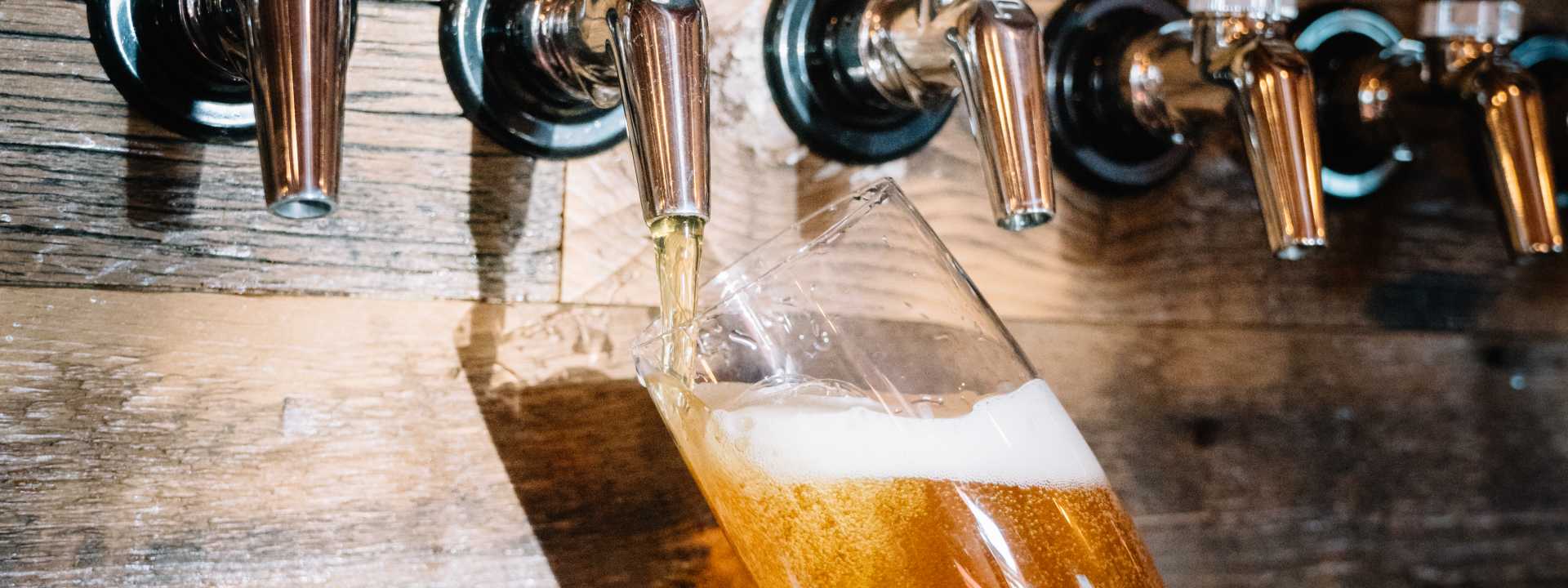 A bartender fills a tall glass from a tap along the New Mexico Ale Trail.