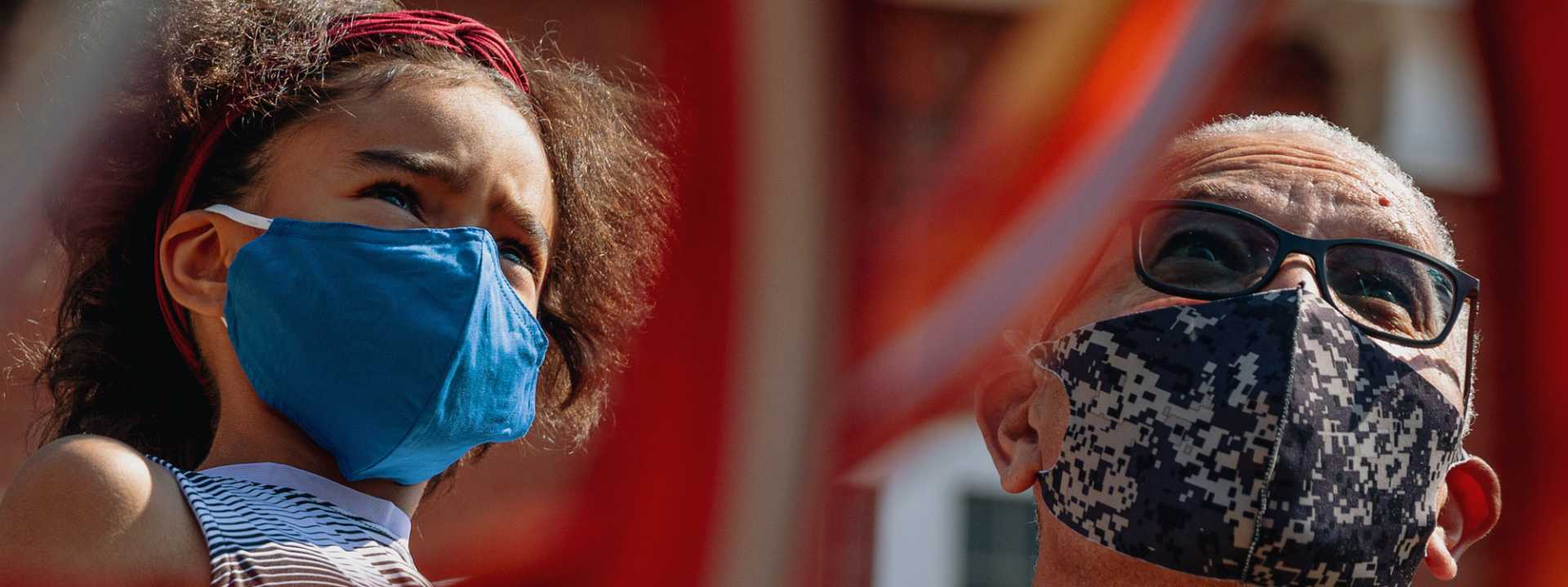 Girl and Grandfather window shopping in masks.