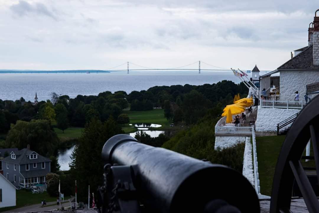 A cannon points out over the water from Mackinac Island’s Fort Mackinac, with the Mackinac Bridge on the horizon