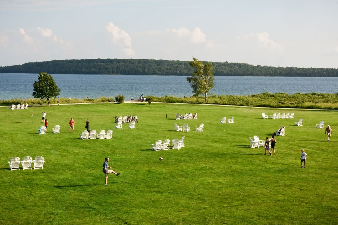A father and son kick a ball on the lawn at Mission Point Resort on Mackinac Island