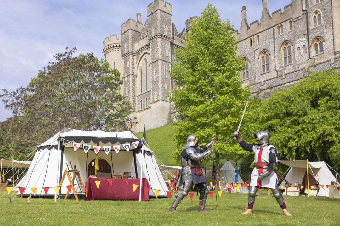 Two knights in medieval costume and armour in the grounds of Arundel Castle, Sussex