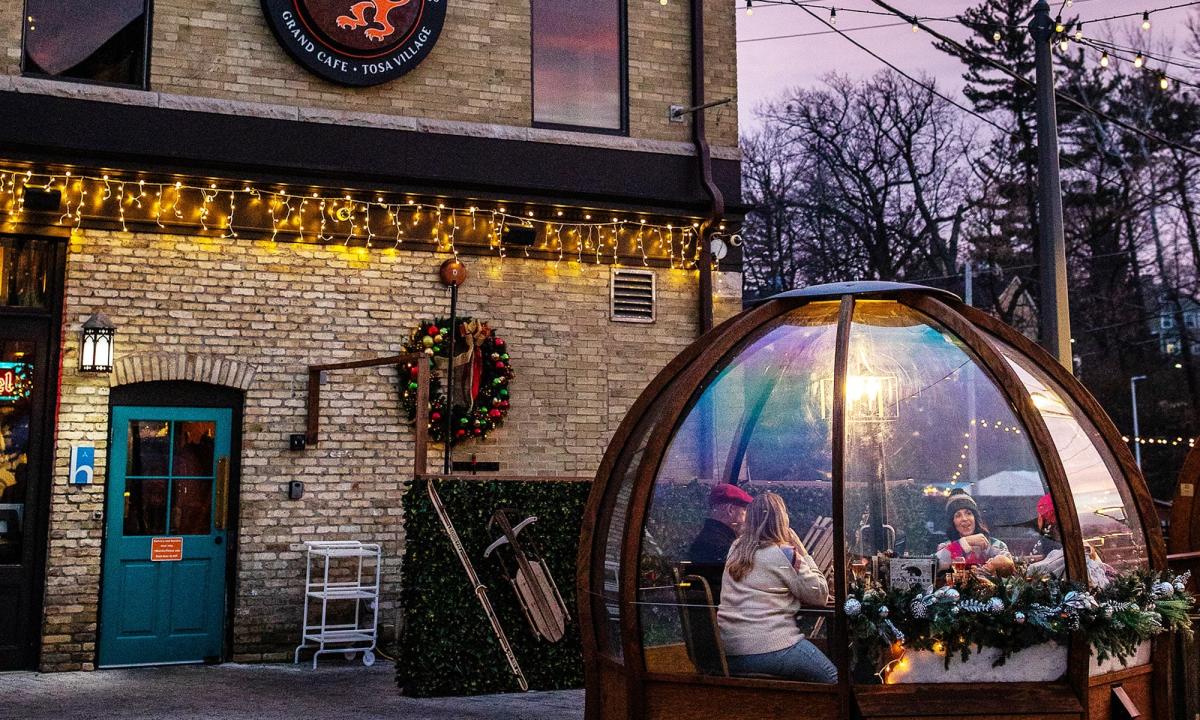 friends eating in a winter dome outside Cafe Hollander in wauwatosa