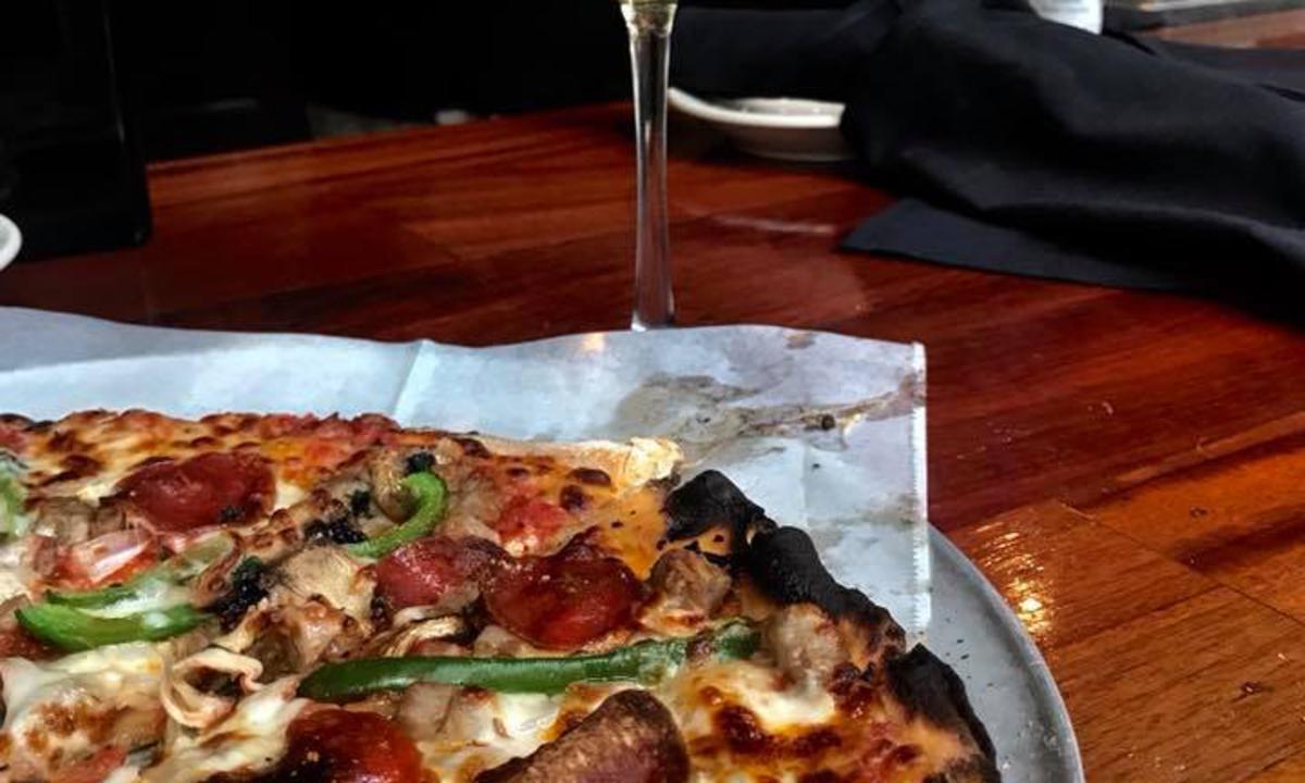 Pizza with glass of wine at Frank's Outback