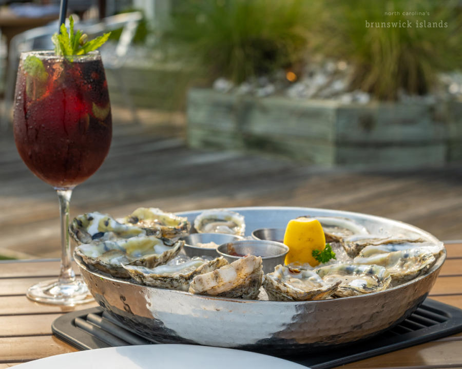 A plate of oysters with a red cocktail