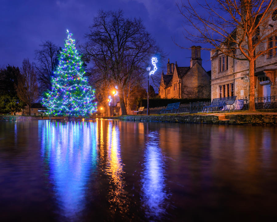 Christmas scene of Bourton with a Christmas tree in the river