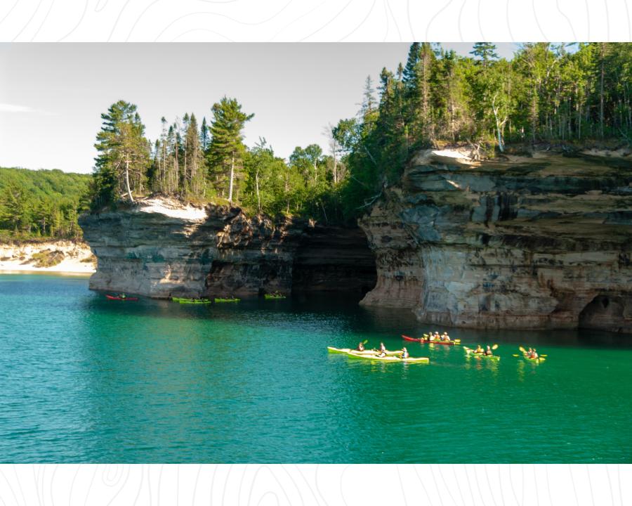 A group of kayakers on a guided tour of Pictured Rocks National Lakeshore near Marquette, MI