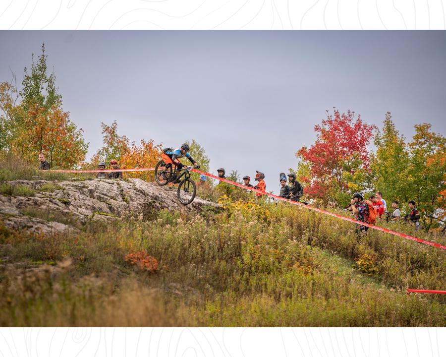 Spectators watching a racer biking down a rock slab on Marquette Mountain at the Fall Enduro in Marquette, MI