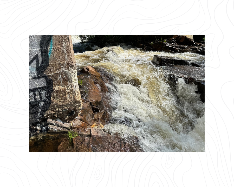 A waterfall next to a graffitied wall