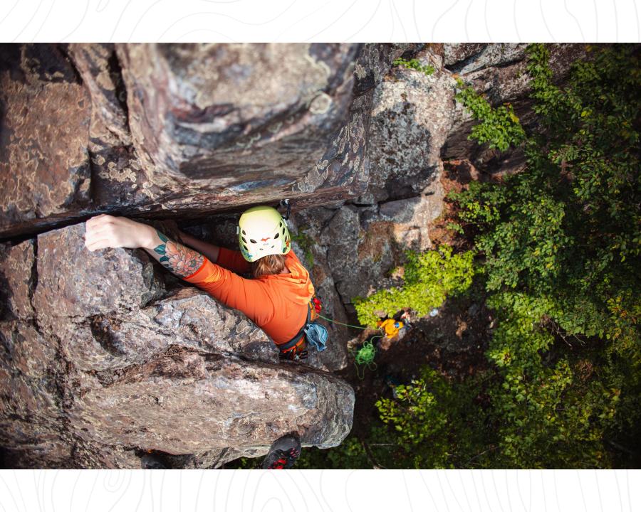 A woman rock climbing in Marquette, MI